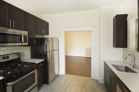 A kitchen with black cabinets and a stove top oven.