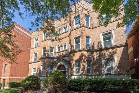 A large red brick building with ivy growing on the side.