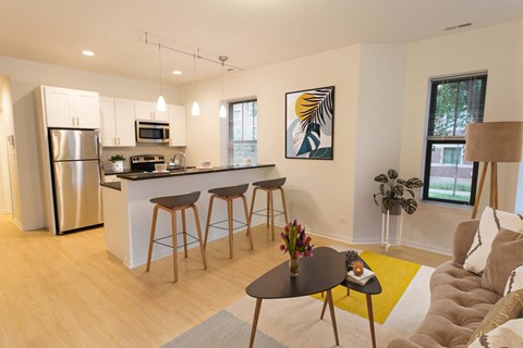 A modern kitchen with a bar and stools.