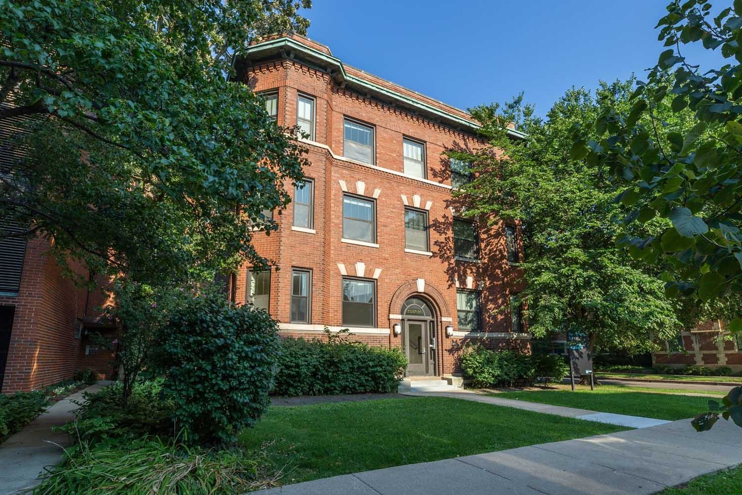 A red brick building with a green lawn in front.