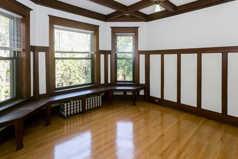 A room with wooden floors and a bench.