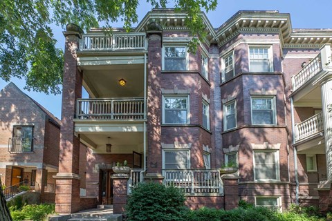 A large red brick building with a balcony on the second floor.