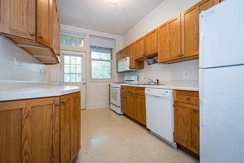 A kitchen with wooden cabinets and white appliances.