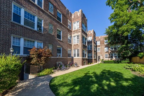 A brick building with a green lawn in front.