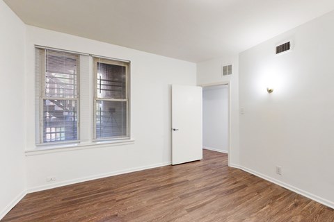 A room with a white wall and a wooden floor.