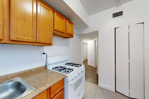 A kitchen with a white stove and wooden cabinets.