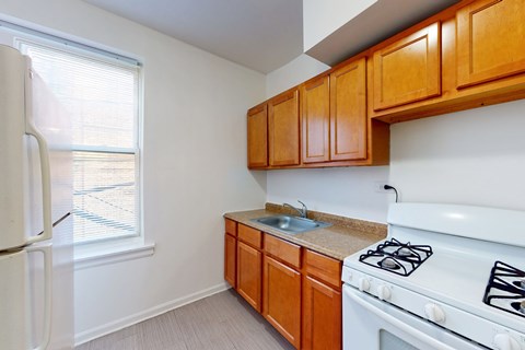 A kitchen with white appliances and wooden cabinets.