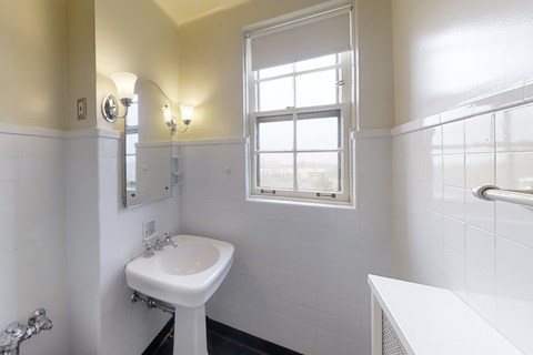 A white sink in a bathroom with a window.