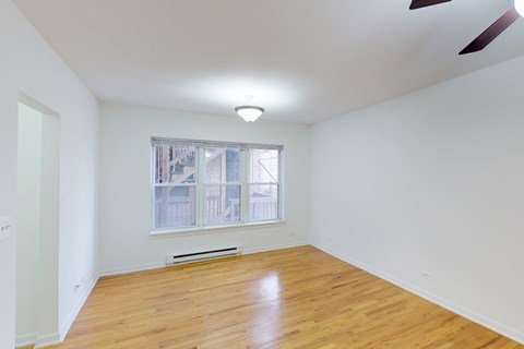 A room with wooden floors and a window overlooking a cityscape.