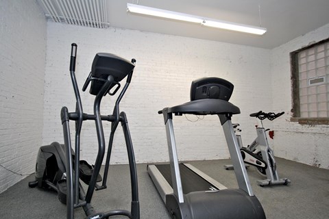 A gym with a treadmill and a stationary bike.