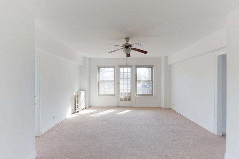 A room with a ceiling fan and a window.