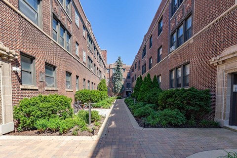 A long brick walkway between two rows of buildings.