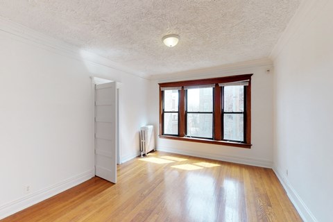 A room with a wooden floor and a window.