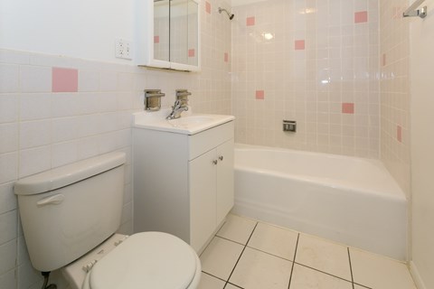 A white toilet sits next to a white sink in a bathroom.