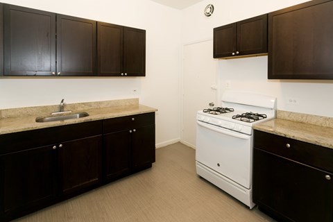 A kitchen with brown cabinets and a white stove.
