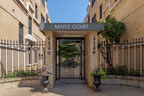 Maple Court is a building with a black gate and a brick facade.