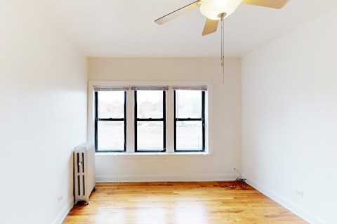 A room with a fan, radiator, and a window.