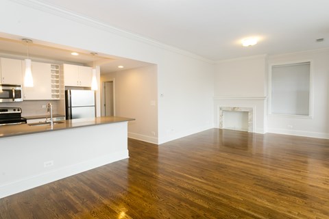 A large empty room with wooden floors and white walls.