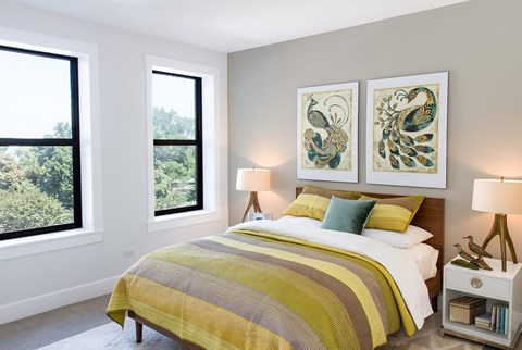 A bedroom with a large bed and two lamps.