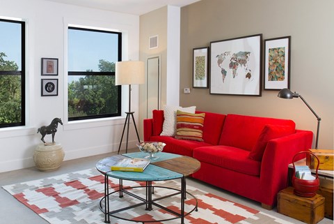 A living room with a red couch and a coffee table.