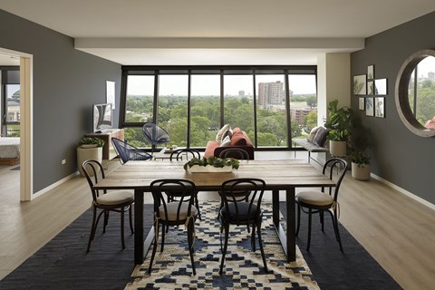 A dining room with a table set for six with a view of the city.