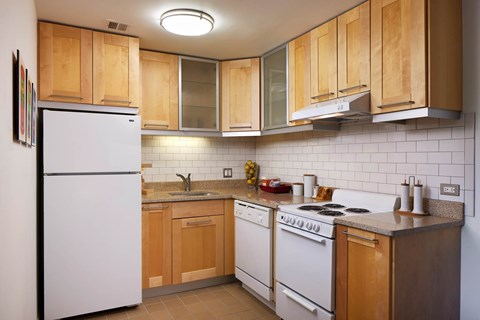 A kitchen with wooden cabinets and a white refrigerator.