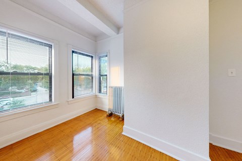 A room with a window and a radiator on the floor.