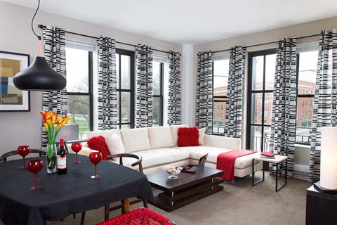 A living room with a black table and white couch.