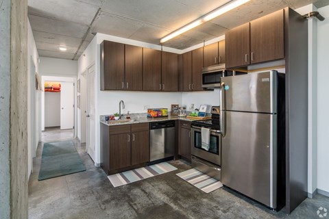 A kitchen with a refrigerator on the right side.
