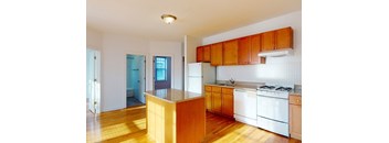A kitchen with wooden cabinets and white appliances.