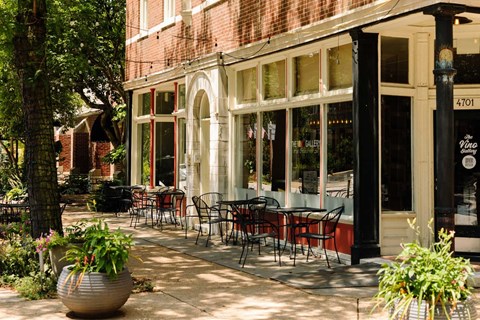 A restaurant with tables and chairs outside.