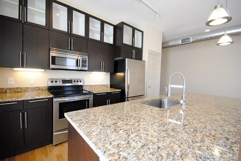 A kitchen with granite countertops and stainless steel appliances.