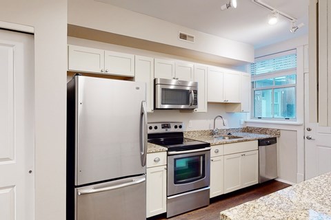 A kitchen with white appliances and cabinets.