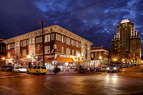 A yellow taxi is parked in front of a building with a lit up sign that says "The".