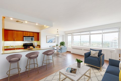 A living room with a bar area and a view of the city.
