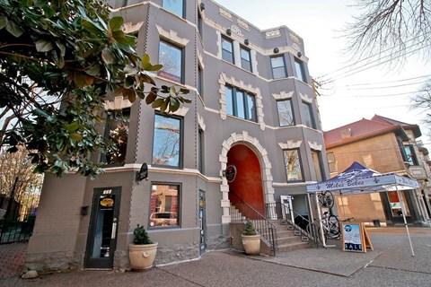 A building with a red door and a sign that says "Mile Bikes" in front of it.