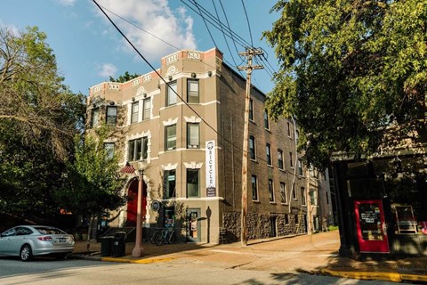 A street view of a building with a red telephone booth in front.