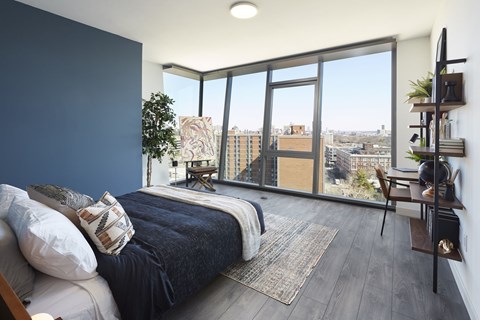 A bedroom with a large bed and a view of the city.
