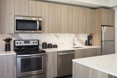 A modern kitchen with a stainless steel refrigerator and a black oven.