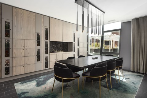 A modern dining room with a black table and chairs.