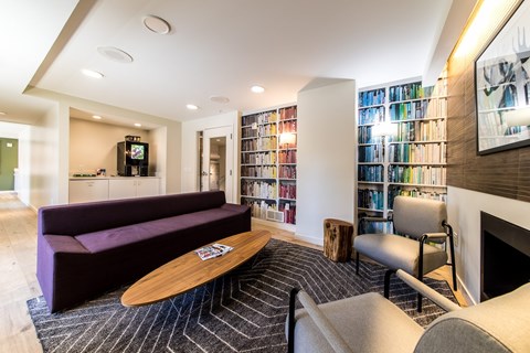 A living room with a purple couch and a fireplace.