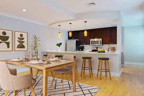 A modern kitchen with a dining table set for two.