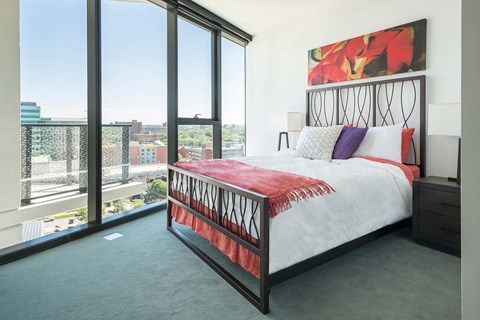 A bedroom with a large bed and a view of the city.