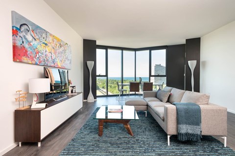 A living room with a couch, a coffee table, and a large painting on the wall.