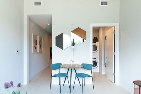 A dining room with a table and chairs.