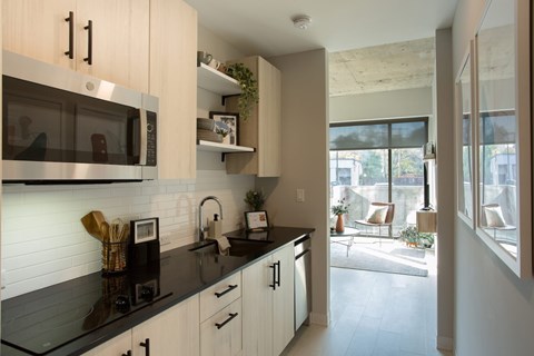 A modern kitchen with a black countertop and white cabinets.