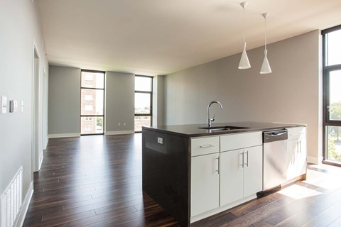 A kitchen with white cabinets and a black countertop.