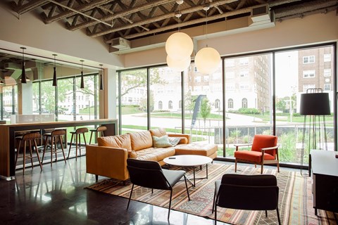 A living room with a large window and a view of a city.
