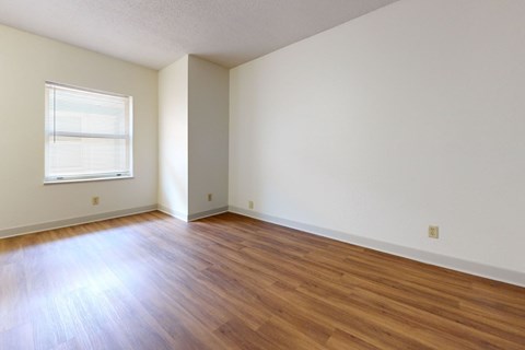 A room with wooden flooring and a window.