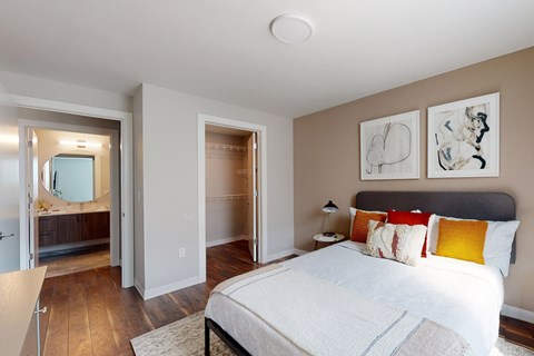 A bedroom with a large bed and a walk-in shower.